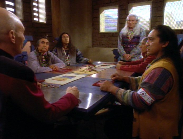 Picard talking to a table of Indigenous American analogues in The Next Generation Episode: “Journey’s End.”