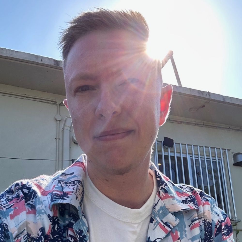 Young white blonde man in a blue, pink, and white kariyushi shirt